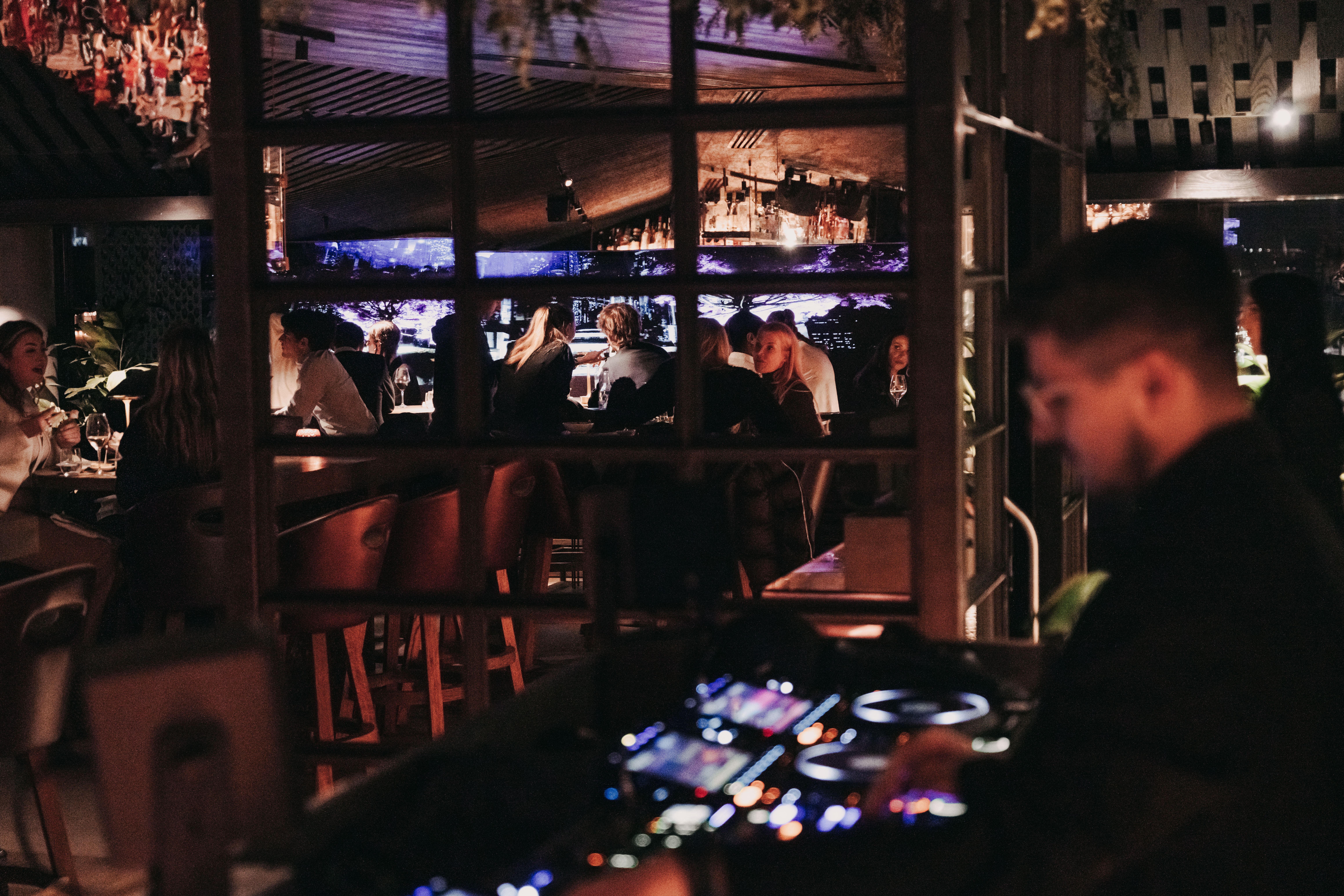 DJ plays music as people enjoy at the CLAP London BAR